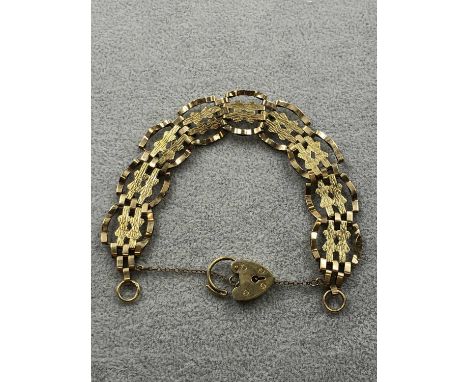 A 9ct hallmarked gold fancy link gate bracelet complete with safety chain and padlock. Weight 10.38 grams. 