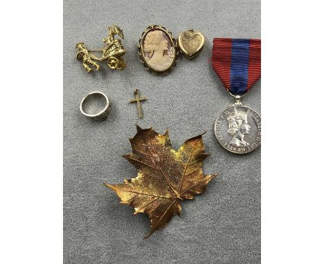A 9ct stamped gold cross, an unhallmarked 9ct gold framed cameo pendant/brooch, a 9ct back &amp; front heart shape locket, a 