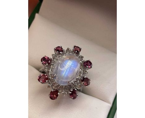 A large cabochon rainbow moonstone, pink tourmaline and diamond ring.Approximate gemstone weights: Moonstone 3.50 cts, Tourma