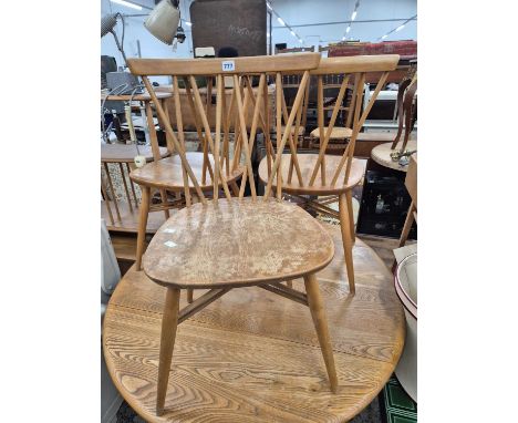 Three retro Ercol side chairs with crossed spindle backs.
