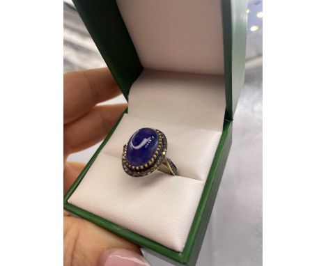 A large cabochon tanzanite and rose-cut diamond ring in silver gilt. Diamonds 0.60 ct, tanzanite 7.20 ct.  Ring size K.
