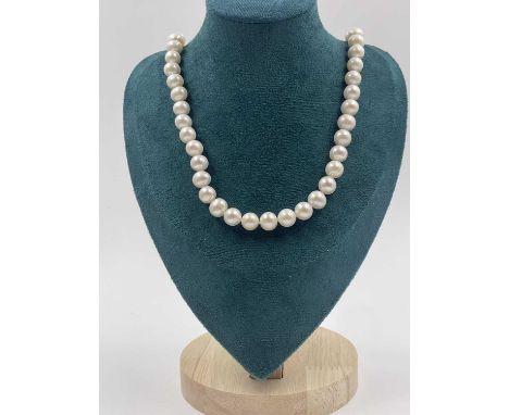 A white cultured pearl necklace with a gold-plated silver ball clasp.  Length 66 cms. 
