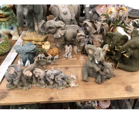 Composition and ceramic elephants together with one under horn palm trees