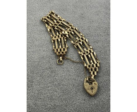 A 9ct hallmarked gold five bar gate bracelet with padlock and safety chain. Weight 10.5 grams. 