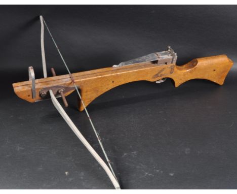 A vintage mid 20th Century wooden crossbow / cross bow. Heavy wooden frame with an elasticated launching device mounted to th