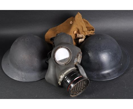 Two WWII Second World War British Army steel Brodie helmets and x1 respirator gas mask. The helmets with original liners and 