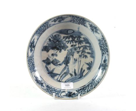 A Swatow porcelain saucer dish, probably 17th century, painted in underglaze blue with a phoenix amongst peony and bamboo wit