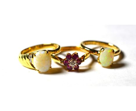 A 9 carat gold ruby and diamond cluster ring, finger size O1/2; an 18 carat gold opal solitaire ring, finger size M; and an 1