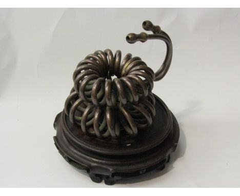 A twisted copper pipe sculpture on Oriental wooden base, 20cm x 18cm