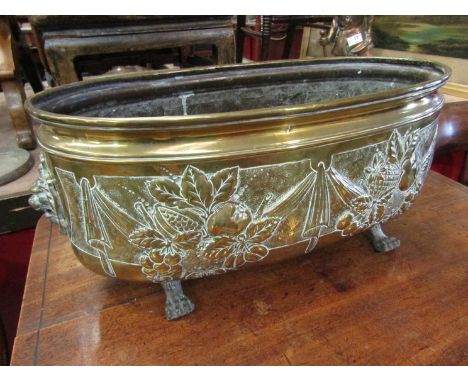 An antique brass planter with paw feet
