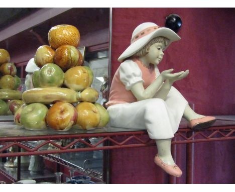 A porcelain shelf figure of a young girl wearing a hat and a ceramic display of fruit  (2)