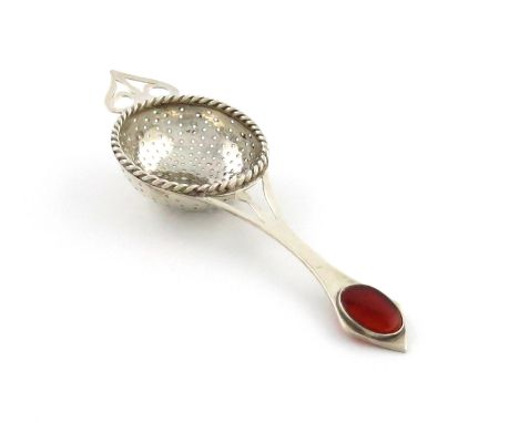 By Sybyl Dunlop, an Arts and Crafts silver tea strainer, London 1926, circular form, rope-work border, pierced handle with an