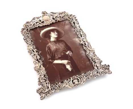 A late-Victorian cast silver photograph frame, by Gibson and Langman, London 1894, shaped upright rectangular form, pierced a