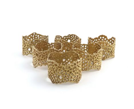 By Stuart Devlin, a set of six modern silver-gilt napkin rings, London 1976, circular form, with a pierced textured decoratio