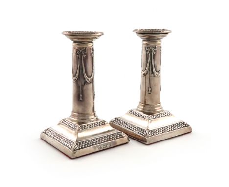 A pair of late-Victorian silver candlesticks, by Isaac Millar Wilkinson, London 1899, the columns with hanging drape decorati