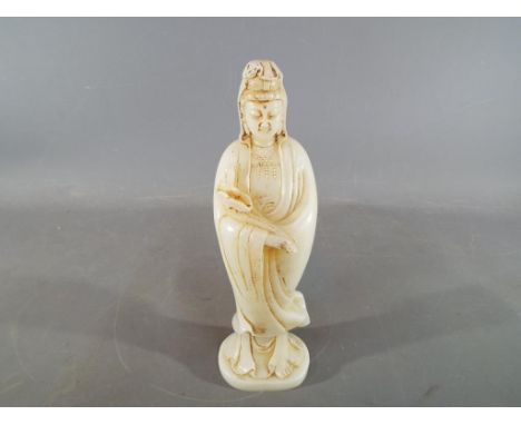 A very rare 18th century Chinese jade or hardstone carving of Guanyin holding a Ruyi sceptre or lotus bud, traces of fine car