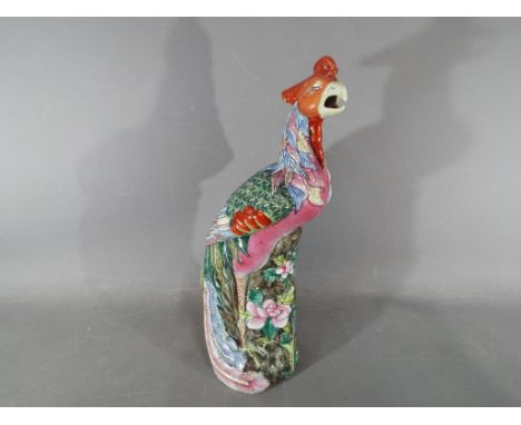 An 18th Chinese famille rose ceramic figurine depicting a Fenghuang (phoenix), impressed marks to the base, approximately 36 