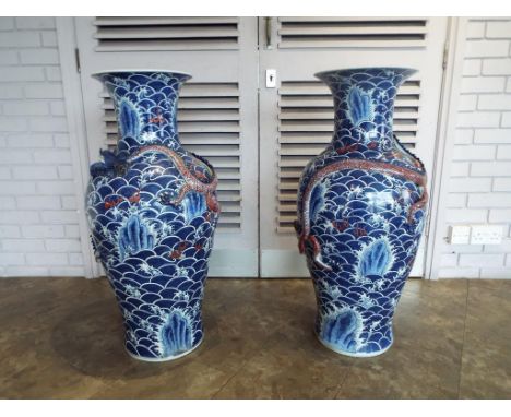 A very large pair of Chinese vases with everted rim and decoration depicting a seascape with rolling waves, rocks, applied fi