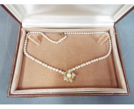A cultured pearl necklace of 90 pearls with 18ct diamond set flower drop pendant, with 10 brilliant cut diamond set petals an