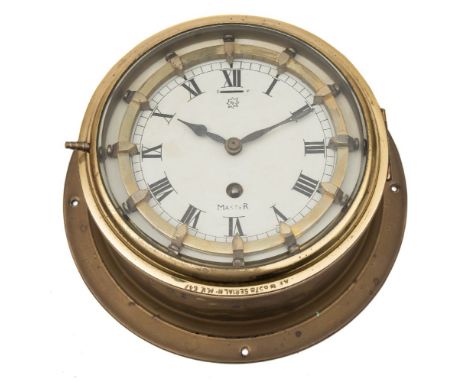 A circular brass bulkhead 'Master' clock:, the single barrel movement with enamel dial and Roman numerals, brass ring with sl