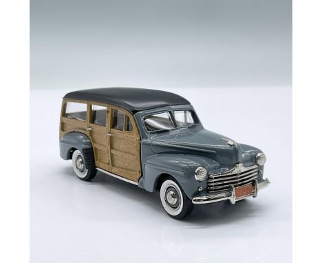 Features a gray and wooden model car with a black roof and tan interior. This small four door collectible is designed at a on