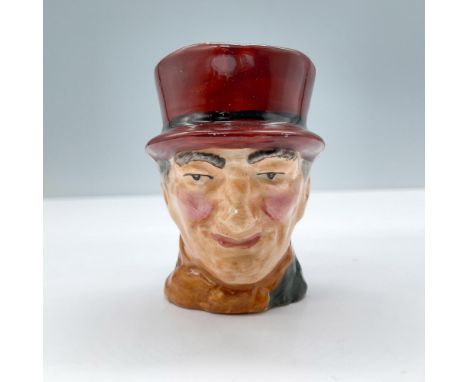 Figural jug of a man in a dark-green coat, orange scarf, dark brown hat with a black band. A riding crop and hunting horn as 