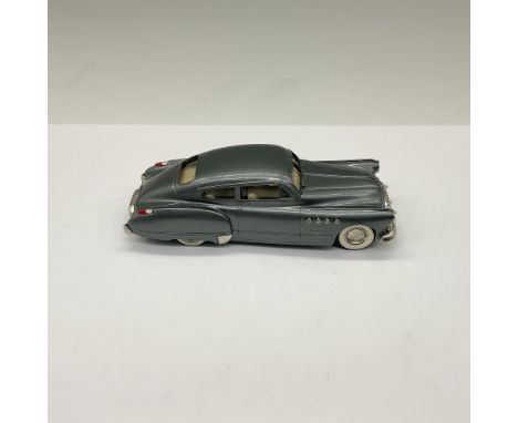 Gray with beige interior and whitewall tires. Marked Brooklin Models. This item has its original box measuring 6"L x 2.25"W x