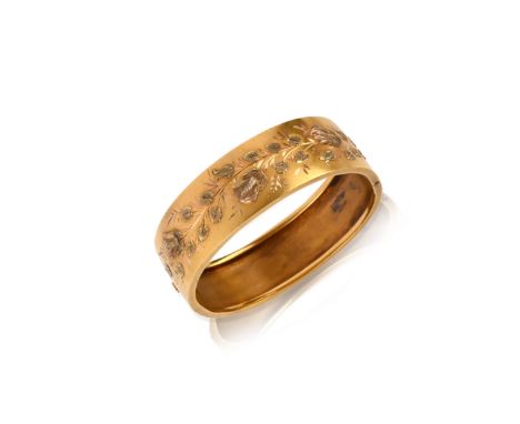 A gold bangle, 19th century, of hinged construction, the front decorated with a design of wildflowers in rose and green gold,