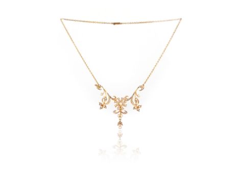 An Edwardian seed pearl-set gold necklace, of scrolling floral design set in closed back yellow gold mount, on fine-link gold