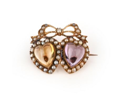 An Edwardian citrine and amethyst heart brooch, the cabochon hearts set within seed pearl surrounds beneath a seed pearl bow 