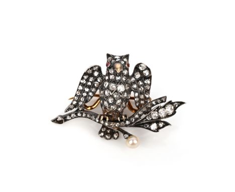 A diamond and pearl brooch, designed as an owl on a branch, set with cushion-shaped and rose-cut diamonds, its eyes set with 
