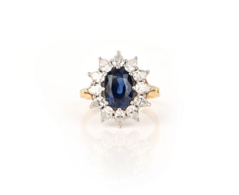 Asprey, a sapphire and diamond ring, claw-set with an oval sapphire within a border of pear-shaped diamonds, size N, British 