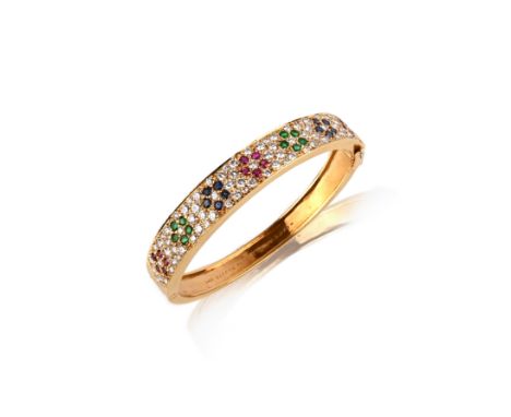 Van Cleef &amp; Arpels, a ruby, emerald, sapphire and diamond bangle, the hinged gold bangle set to the front with floral arr