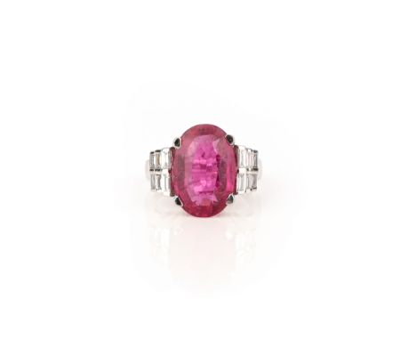 A tourmaline and diamond ring, claw-set with an oval pink tourmaline, to shoulders set with double rows of baguette diamonds,