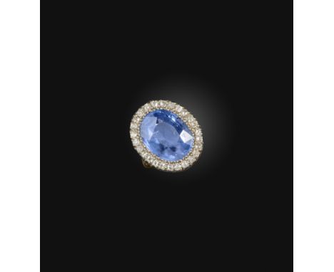 A sapphire and diamond cluster ring, set with an oval sapphire weighing approximately 11.00 carats, within a border of circul