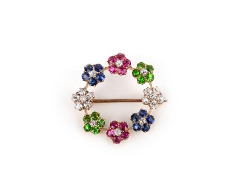 An Edwardian gem-set gold wreath brooch, set with ruby, sapphire and demantoid garnet flowerhead clusters with diamond centre