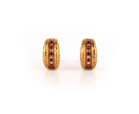 A pair of ruby and diamond earrings by Grima, set with a central line of channel-set rubies and diamonds within hammered yell