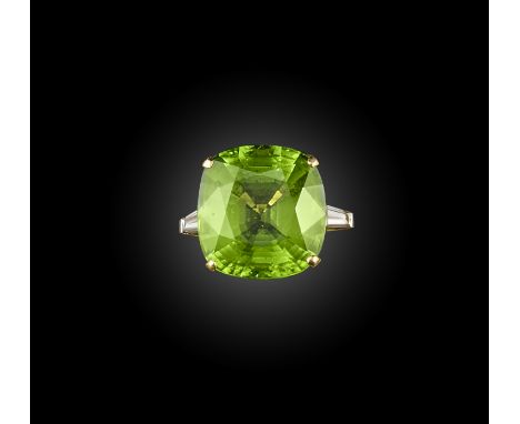 A large peridot and diamond ring, the cushion-shaped peridot, weighing 27.08cts between tapering baguette-cut diamonds, in 18