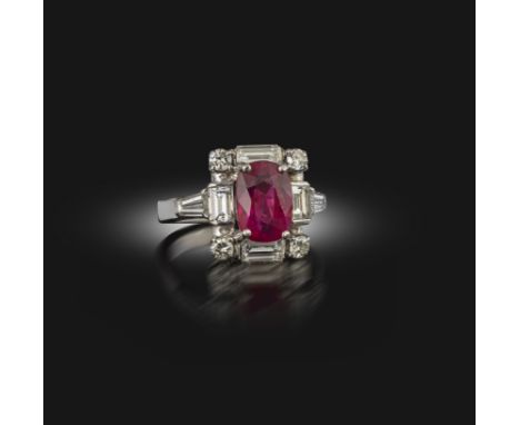 A ruby and diamond ring, set with an oval ruby weighing approximately 2.50 carats, within a geometric mount set with baguette