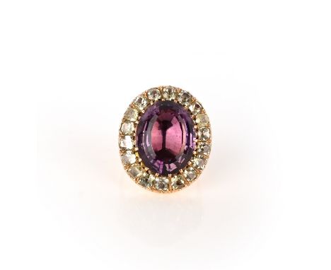 An amethyst and chrysoberyl ring, claw-set with an oval step-cut amethyst within a border of cushion-shaped chrysoberyls, mou