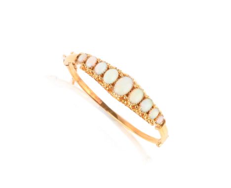 An opal bangle, the hinged gold bangle set to the front with nine graduated opal cabochons in closed-back claw settings, inne