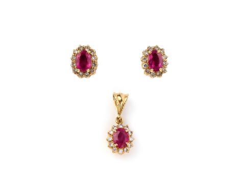 A ruby and diamond demi-parure, comprising a pair of stud earrings and a pendant, each composed of an oval ruby within a bord