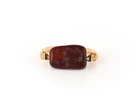 A jasper intaglio ring, set with a rotating jasper bead of triangular cross section carved with intaglios of two figures and 