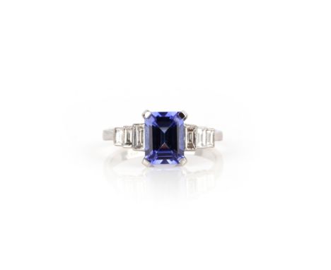 A tanzanite and diamond half hoop ring, set with an emerald-cut tanzanite weighing 1.75cts within graduated baguette-shaped s