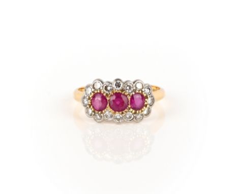 A ruby and diamond triple cluster ring, set with three circular-cut rubies within a border of diamonds in gold, London hallma