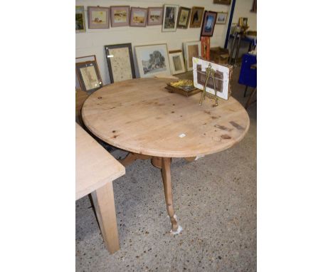 A modern circular pine dining table on turned colum and tripod base