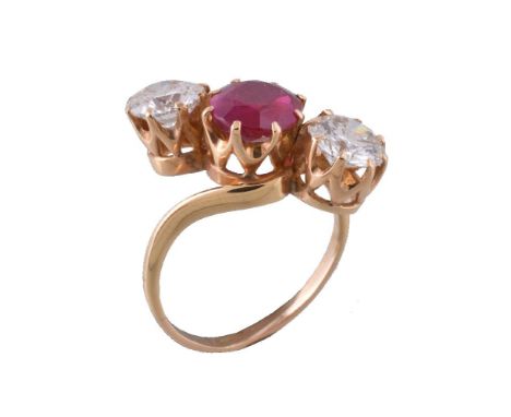 A three stone ruby and diamond crossover ring, the central oval cut ruby estimated to weigh 1.82 carats, claw set between bri