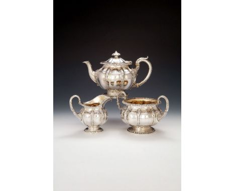 ϒ A George IV silver three piece tea service by Paul Storr, London 1822 and 1823, the tea pot with a lobed button finial to t