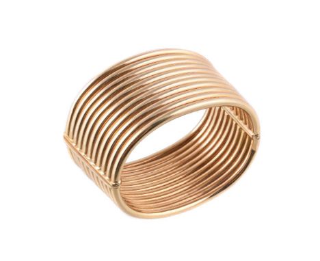 A broad gold coloured cuff bangle by Weingrill, the tapered hinged bangle composed of eleven rows of polished tubes, 6cm wide