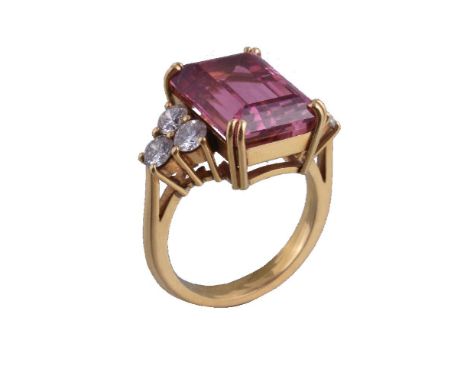 A pink tourmaline and diamond ring, the central rectangular cut pink tourmaline estimated to weigh 9.03 carats claw set betwe